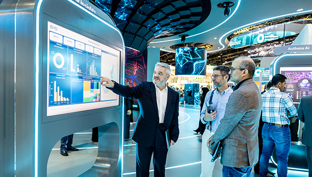  WHX Dubai attendees looking at a screen with graphs